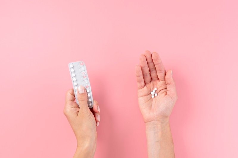 Hands holding a blister pack of birth control pills, emphasizing contraceptive care at Jivika Gynae Clinic.