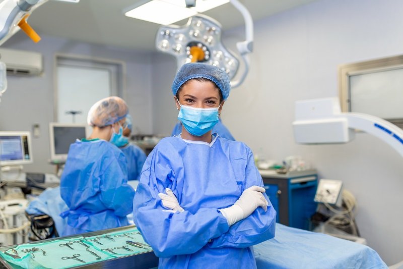 A female surgeon in full surgical attire standing confidently in an operating room at Jivika Gynae Clinic.